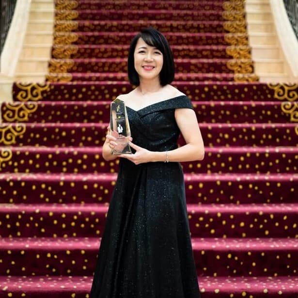 Vinsure principal holding an award on a staircase